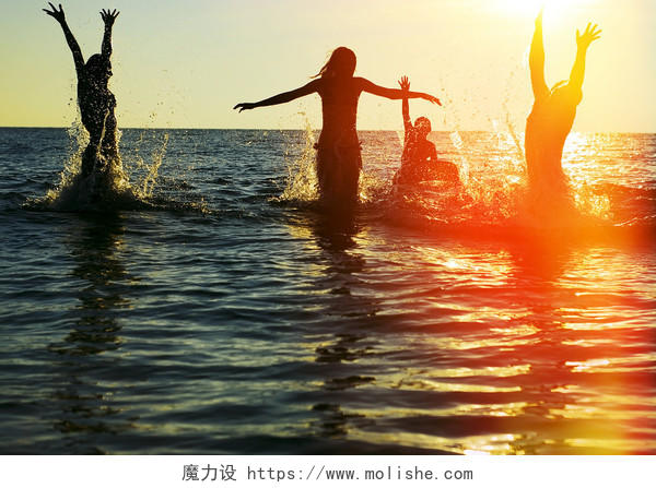 日落黄昏年轻人在海水里玩耍青春励志